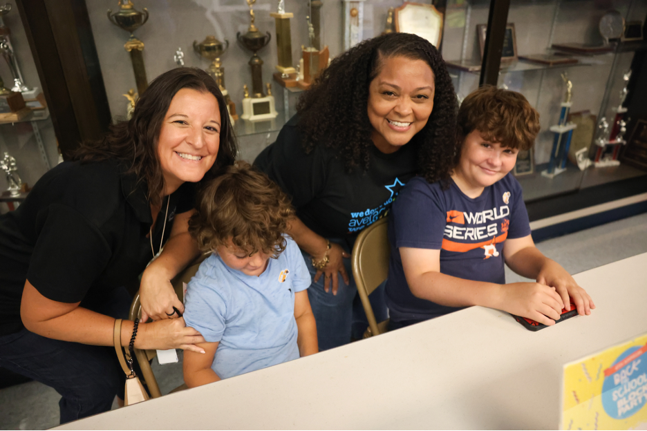 Two adults and two children gathered around a table at Bright Futures Academy.